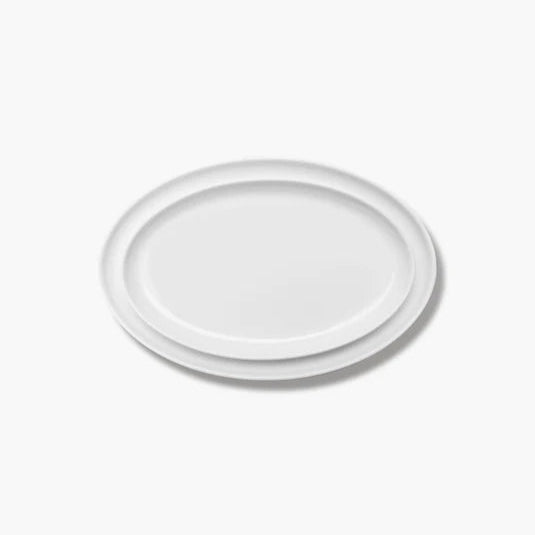 Een set van twee Serax Passe-Partout ovale borden in wit mat, elegant gepresenteerd op een horeca-tafelsetting.